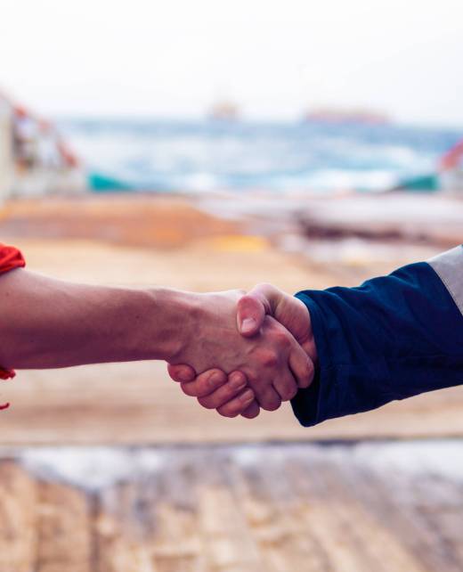 marine contractor businessman handshaking with worker on the ship. Handshake of two boilersuits with different color. Business shipping background